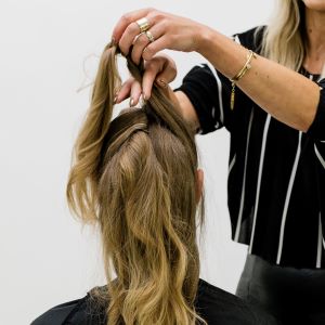 Hair stylist Anna Peters pins the top section of her client's hair for a faux shag look.